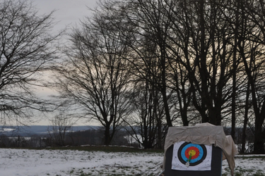Winterlandschaft mit Heuballen, auf dem ein Kreis für Pfeilschießen markiert ist